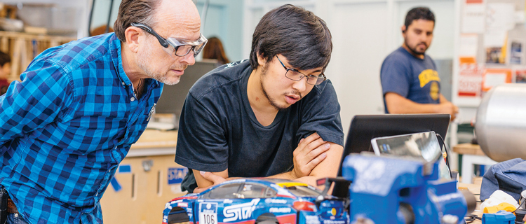 Two men collaborating on a computer in a laboratory, engaged in research and analysis. 